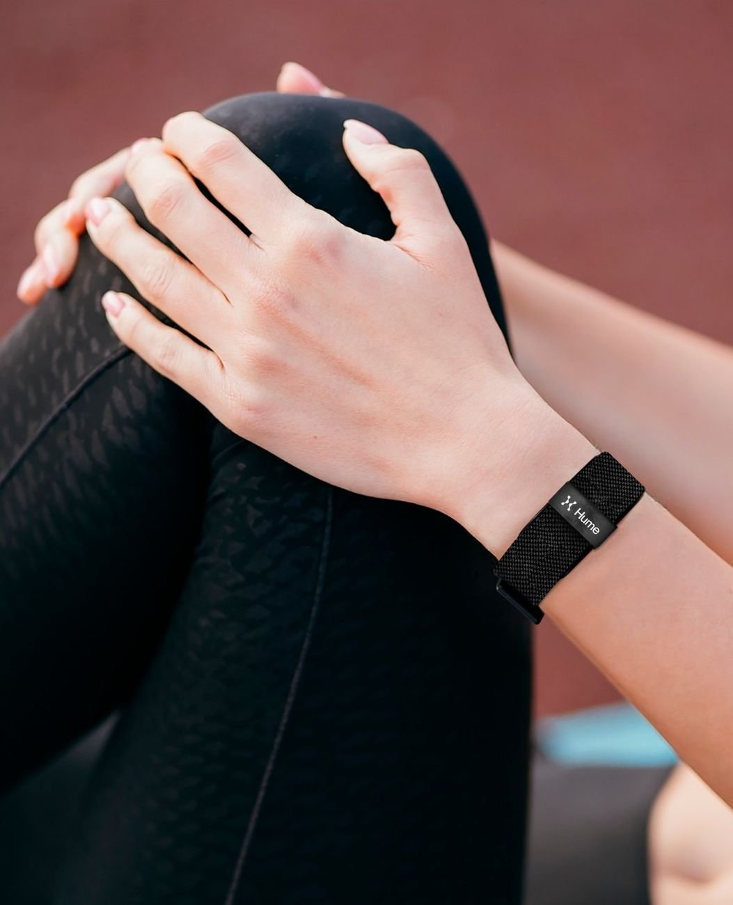Close-up of hands with the Hume Band on the wrist during a stretching routine